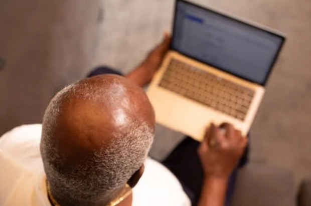 bald man using a laptop